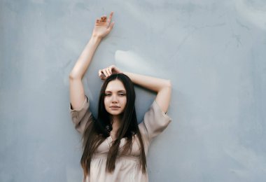 dalgın kız gri bir arka plan karşı eğilir