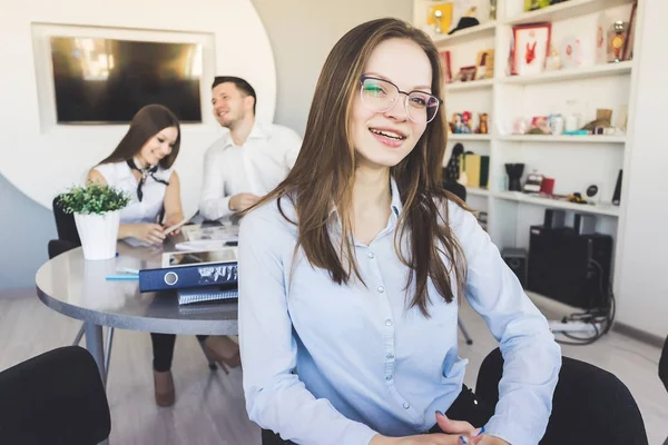 Drei junge Leute lachen und lächeln in Business-Anzügen im Büro — Stockfoto