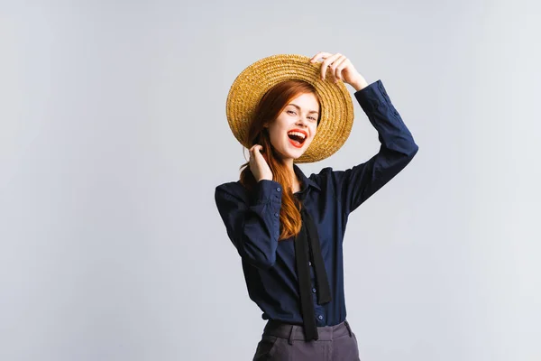 Sorridente ragazza in un cappello lo corregge su uno sfondo bianco — Foto Stock