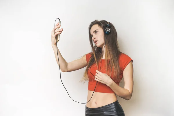 Woman in headphones,selfie on mobile on a white background — Stock Photo, Image