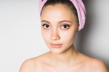 kız beyaz bir arka plan üzerinde gülümseyen başında bir havlu ile