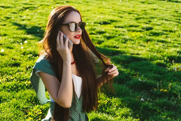 Woman talking with mobile, speaking, smiling. Girl in sunglasses