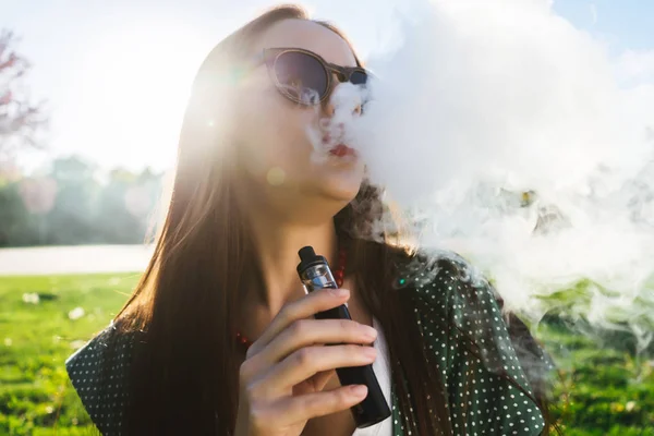 Felice moda sorridente Donna in occhiali da sole fumo vaporizzatore sulla strada, fumo — Foto Stock