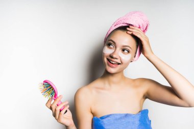 Kafasındaki bir tarak tutan bir havlu ile kız