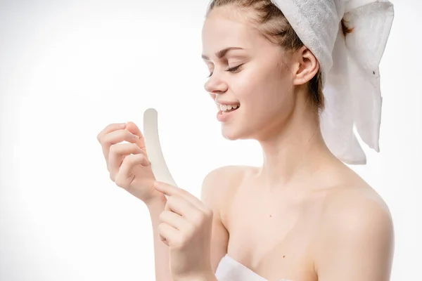 Девушка с полотенцем на голове заботится о своих ногтях — стоковое фото