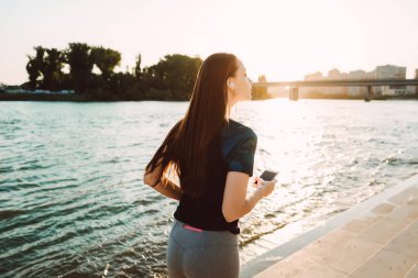 nehir kenarında bir kız ellerini bir telefon ile çalışır