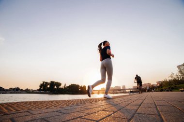 Aşağıdan bir nehir manzarası arka plan üzerinde çalıştırmak bir akşam kız gerçekleştirir