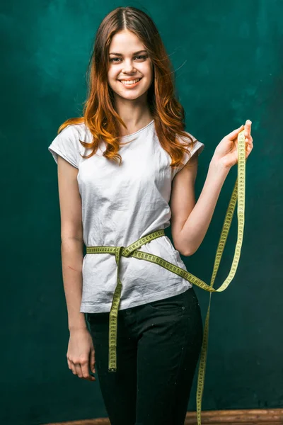 Menina sorridente feliz medindo seu tamanho da cintura — Fotografia de Stock