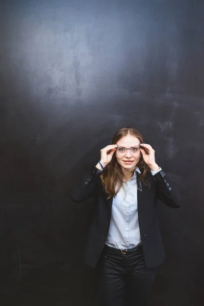 Fille secrétaire surpris tenant ses lunettes sur un fond noir — Photo