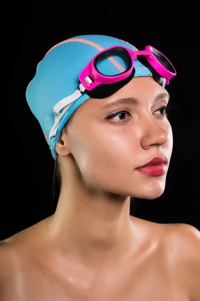 Chica en una gorra de natación para el cabello sobre un fondo negro —  Fotos de Stock