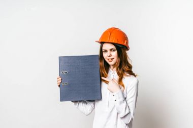 Genç kadın inşaat işçisi kask bir klasör tutarak ve bunda işaret içinde