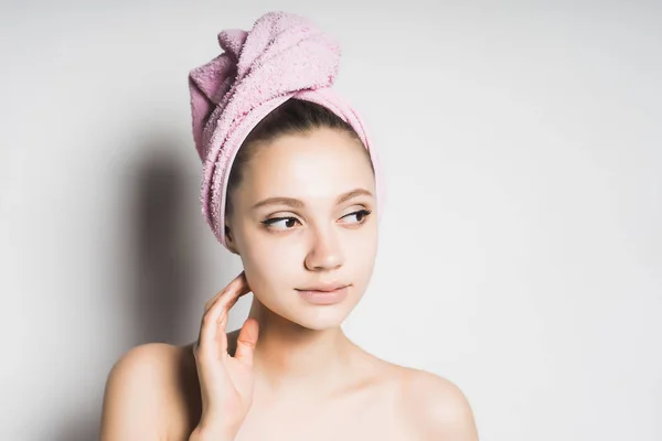 Κορίτσι με μια πετσέτα εξετάζοντας σκεπτικώς στο πλευρό συναίσθημα το πρόσωπό της — Φωτογραφία Αρχείου