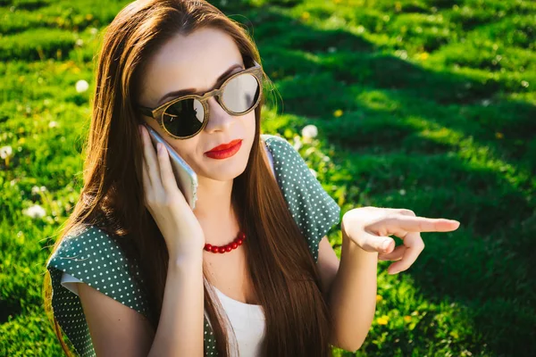 Woman with smartphone pointing to. Girl in sunglasses,summer — Stock Photo, Image