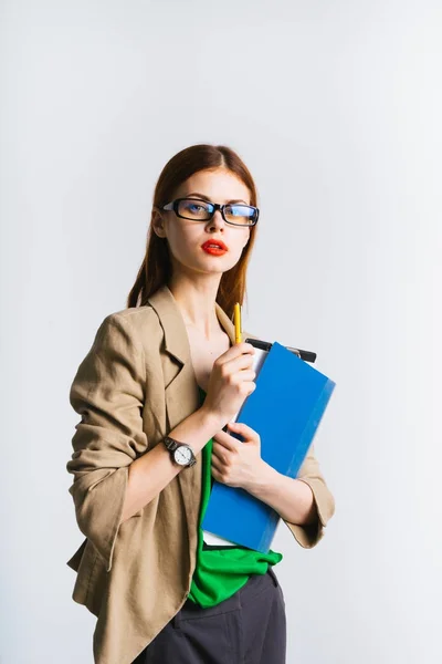 Eine alarmierte junge Geschäftsfrau im Brillenanzug hält Dokumente in der Hand — Stockfoto