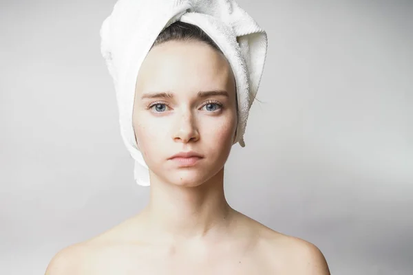 Красивая женщина с полотенцем на голове смотрит в камеру — стоковое фото