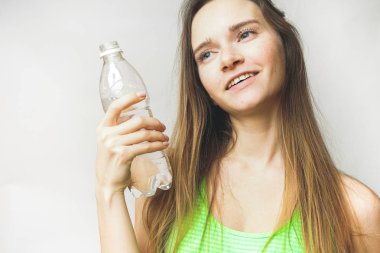 Uzun saçlı kız gülümseyen kadın şişe su ile keyfini çıkarın