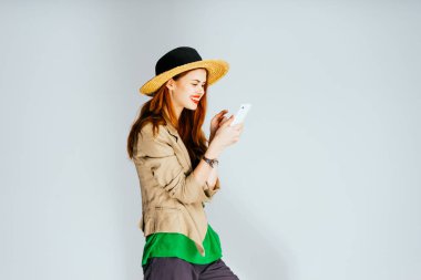 Kırmızı dudaklar ile şapkalı kız görünüyor telefon ve gülümsüyor, mutlu an