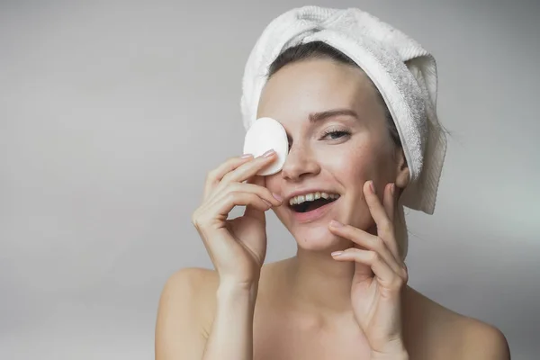 Beautiful woman cleaning her face with cotton swab  and smiling,Shows round swab — Stock Photo, Image