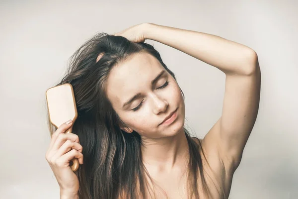 Wanita bahagia menyisir rambut dengan sisir, gadis dengan mata tertutup — Stok Foto