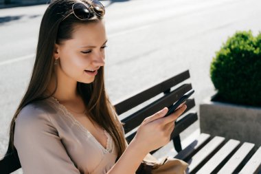 parkta bankta oturan ve seyir telefon güzel uzun saçlı kız