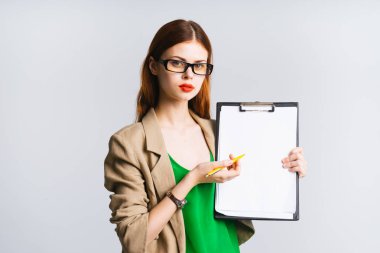 Kızıl saçlı kız gözlüklü ve kırmızı dudaklar ile bazı notlar A4 yaprak üzerinde gösterir.