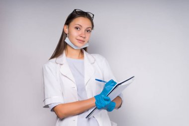 bir kız bir tıbbi elbise hastalar hakkında notlar yapacak