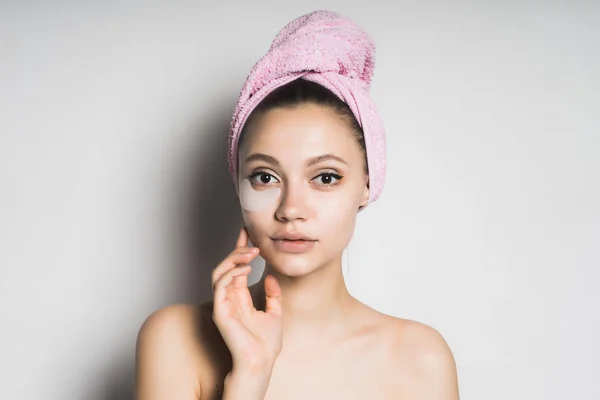 Mädchen nach der Dusche mit Pflastern unter den Augen, die in die Kamera schauen und ihre Hand in der Nähe des Gesichts halten — Stockfoto
