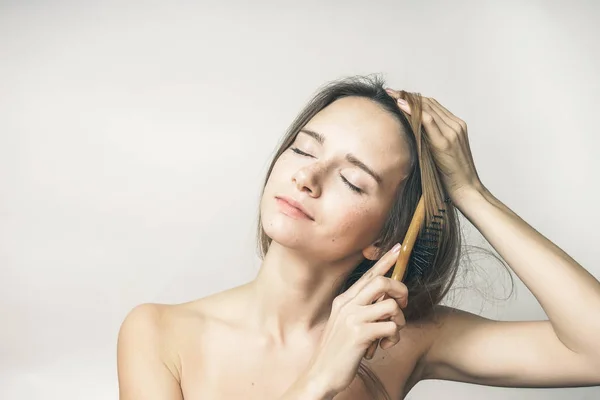 Woman brushing her hair with enjoy closed eyes — Φωτογραφία Αρχείου