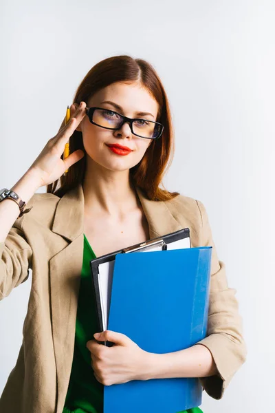 Smart rothaarige Mädchen mit Brille hält Dokumente und einen Bleistift in den Händen und schaut weg — Stockfoto