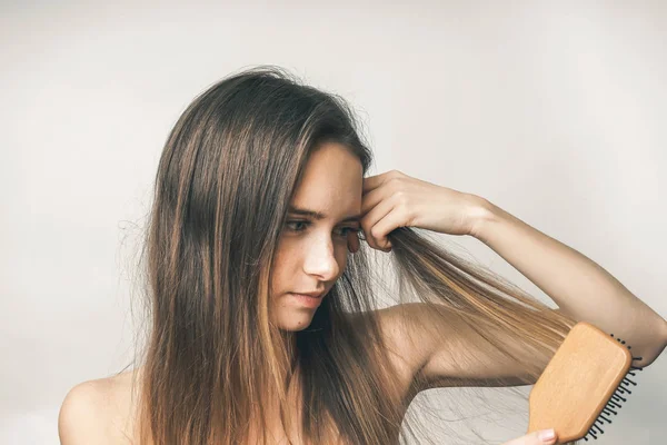Mulher feliz pentear cabelos com pente, menina agradável, cabelo longo — Fotografia de Stock