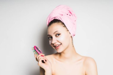 Kafasındaki bir tarak tutan bir havlu ile kız