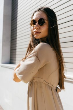 güneş gözlüklü bir yolda mutlu kız kameraya görünüyor