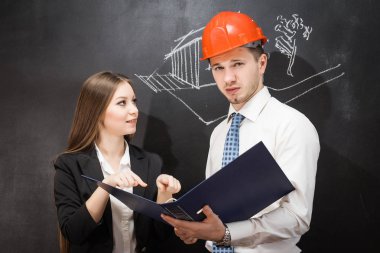 iş takım elbiseli iki genç insanlar aktif olarak ellerini klasöründe gösterilen bir şey görüşüyorlar