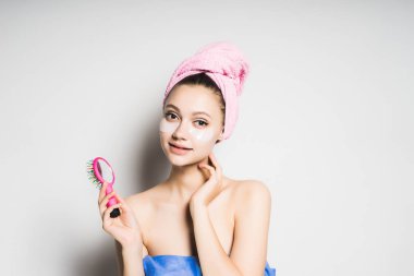 kız yüzünü fırçalama bir tarak tutan başında bir havlu ile