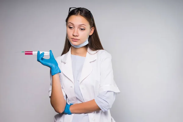 Spiacente infermiera ragazza in possesso di una siringa preparata in mano — Foto Stock