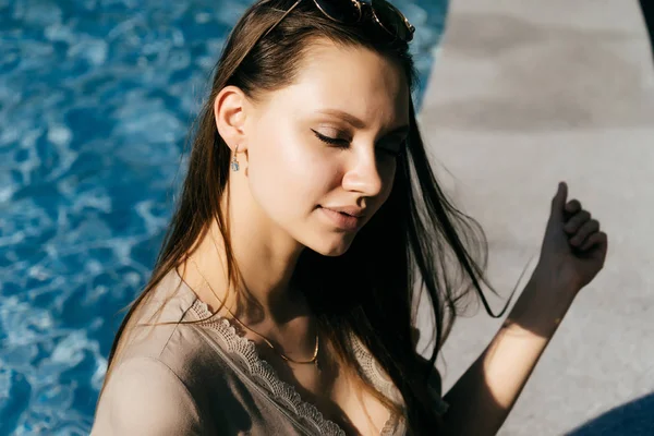 A young girl closes her eyes and rests at a large fountain — Stock Photo, Image