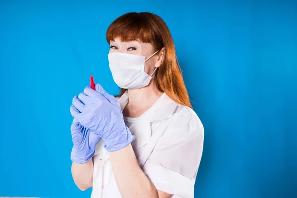Kvinna läkare i en medicinsk mask leende hålla en penna — Stockfoto