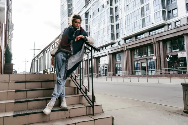 Kız büyük bir cam merdiven tarafından poz bina arka plan üzerinde