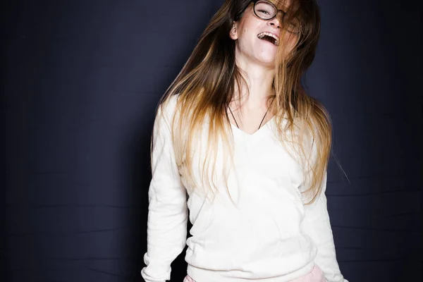 Chica divertida con gafas podches y risas, aislado sobre un fondo azul — Foto de Stock