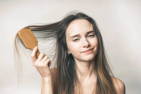 Adolescente com pente de cabelo, sem problemas, a menina está olhando para a câmera — Fotografia de Stock