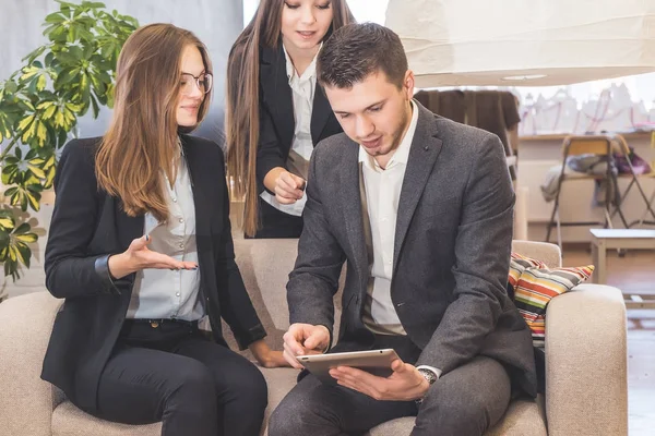 ofiste oturan ve tablet vasıl arayan gençler