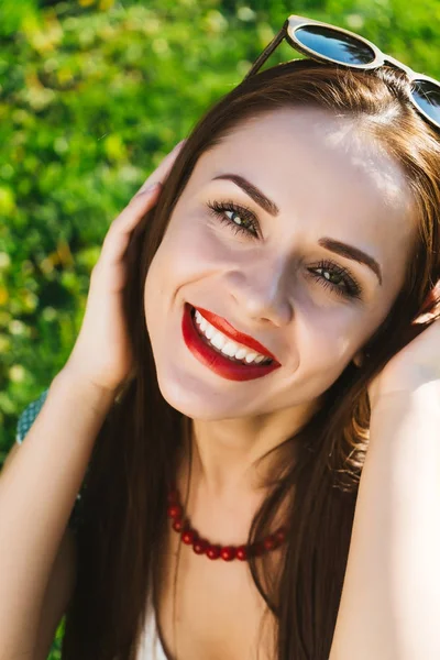 Glücklich lächelnde Frau mit Sonnenbrille auf einem Gras — Stockfoto