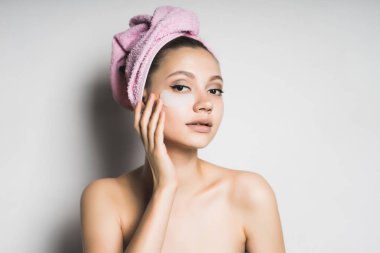 Kız başında bir havlu ile yüzünde bir maske koyar.