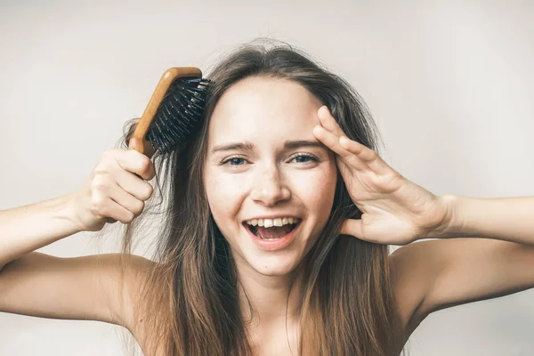 Смешное лицо женщины без проблем с волосами, расческа в руке — стоковое фото