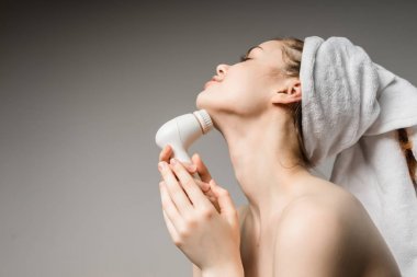 Kız başında bir havluyla yüzünü temizler