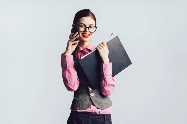 Mädchen mit Brille und rotem Lippenstift lächelt und hält einen Ordner in der Hand — Stockfoto