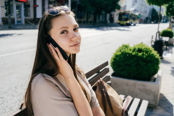 Дівчина сидить на вулиці і розмовляє по телефону — стокове фото