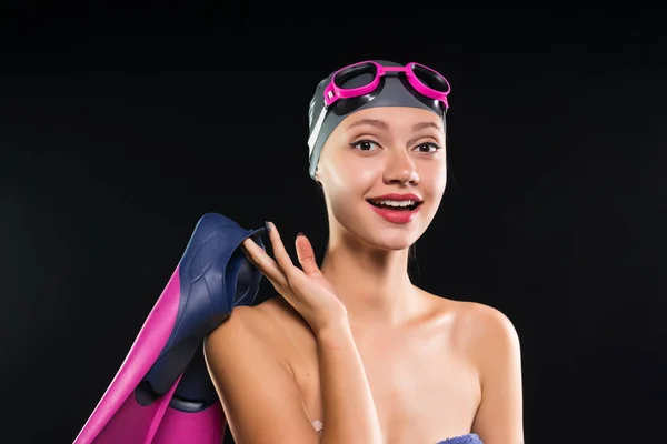 Menina em um chapéu de natação sorridente segurando nadadeiras — Fotografia de Stock