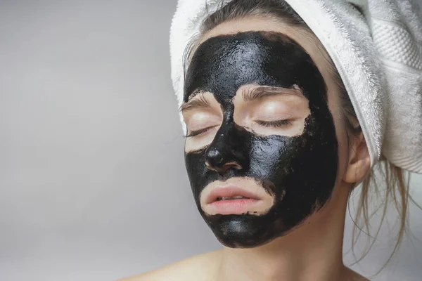 Máscara preta no rosto da mulher, sorrindo, cuidados com a pele, poro de limpeza, contra a acne — Fotografia de Stock