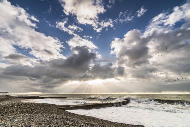 gün batımında fırtınalı havalarda boş taş plaj